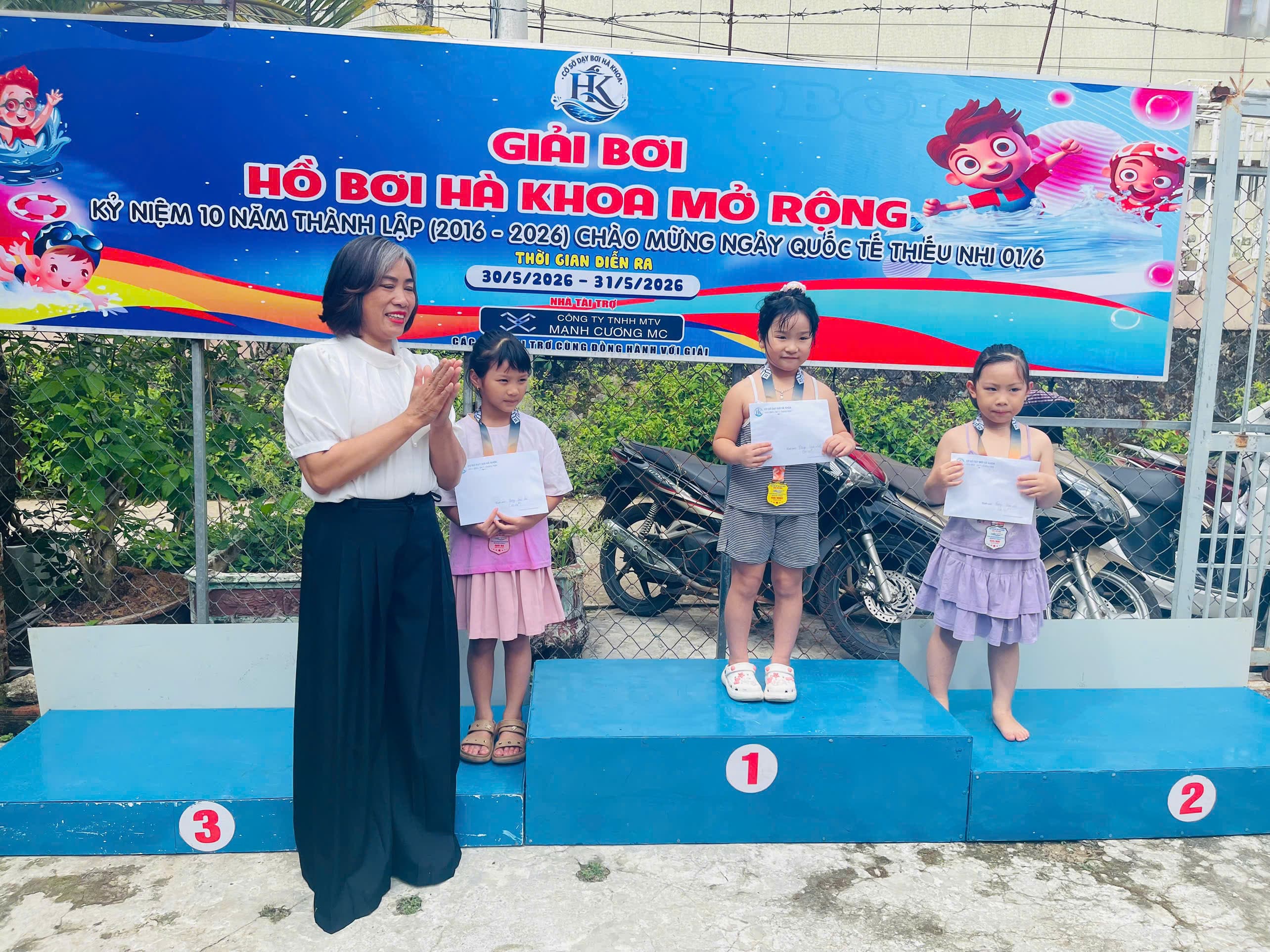 Ba vận động viên nhỏ tuổi nhận huy chương và giấy chứng nhận