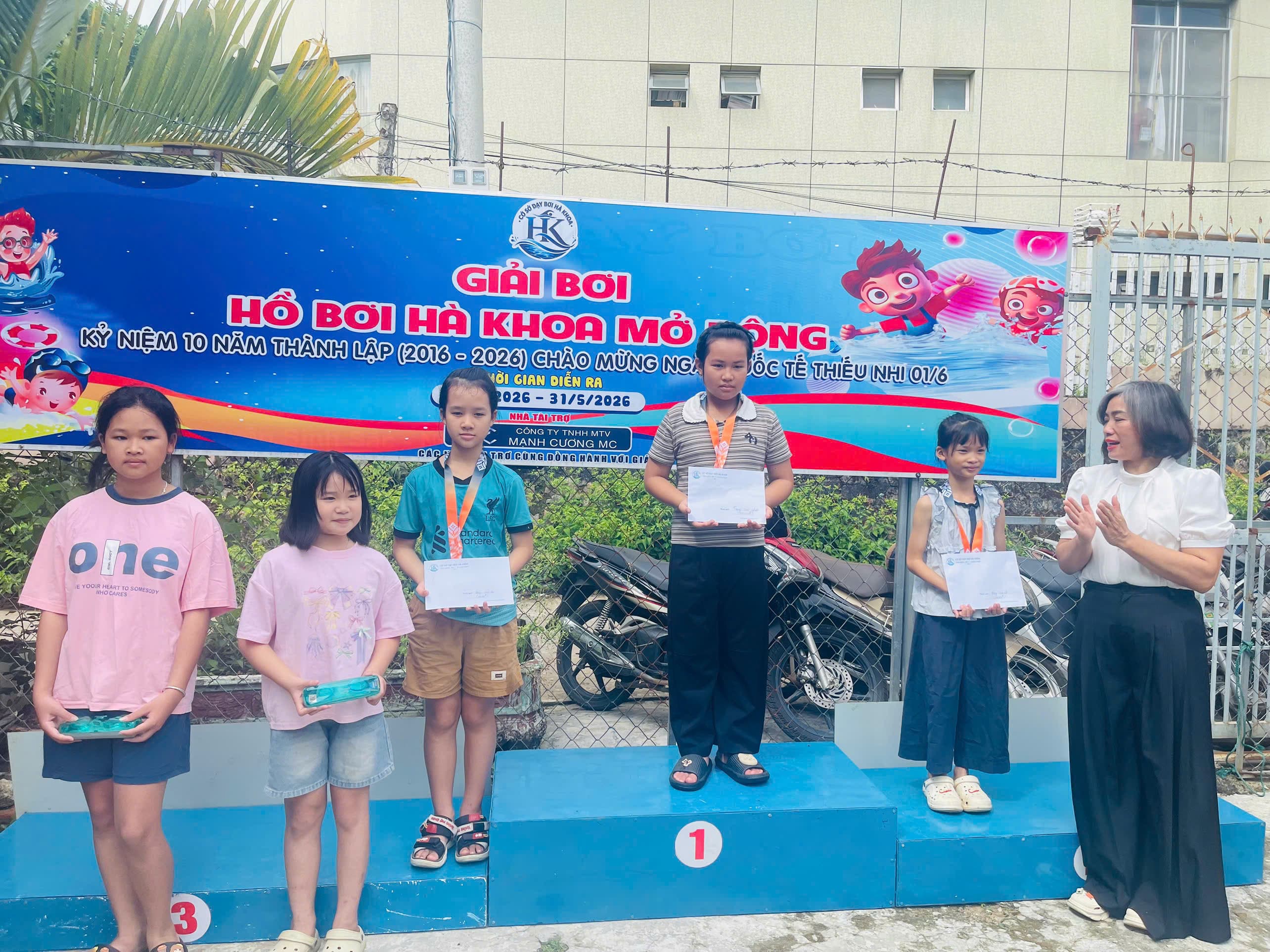 Các vận động viên nữ nhận huy chương và giấy chứng nhận tại giải bơi