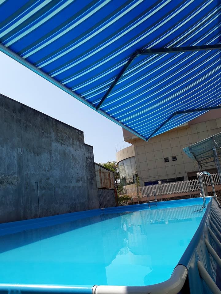 Hồ bơi với mái che kẻ sọc xanh trắng